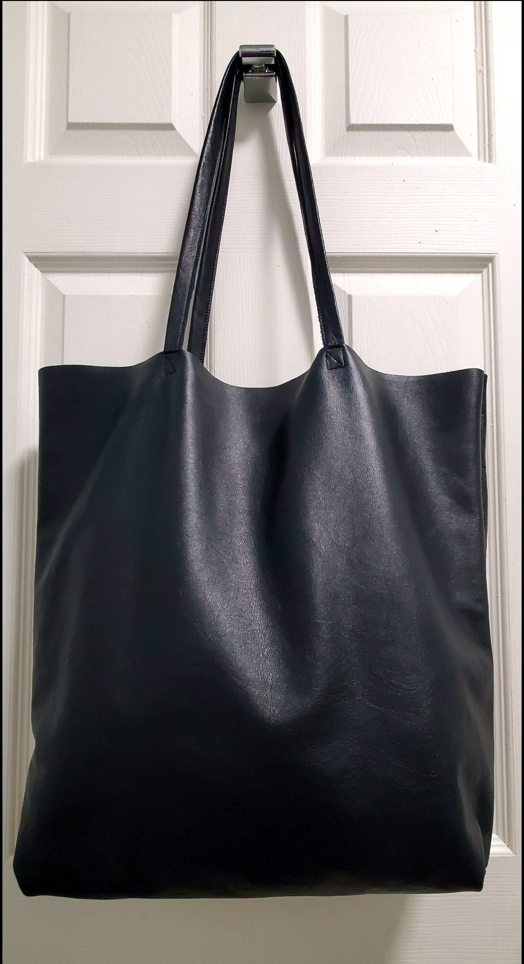 Black leather tote bag thats 18 inches long and 15 inches wide with double inside pockets handcrafted in los angeles california