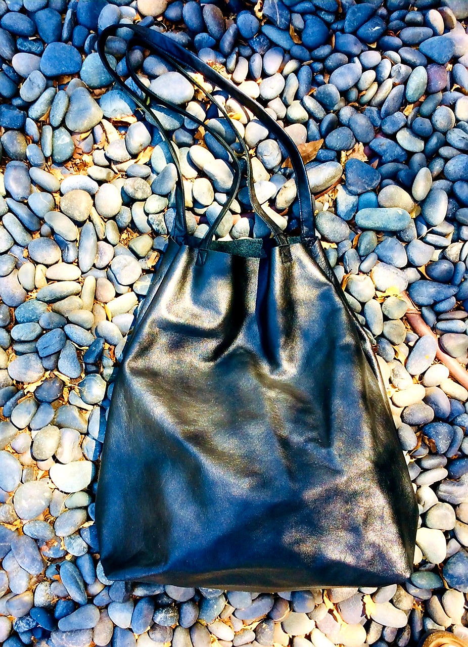 Black leather tote bag thats 18 inch long by 15 inch wide with double inside pockets handcrafted in Los Angeles California