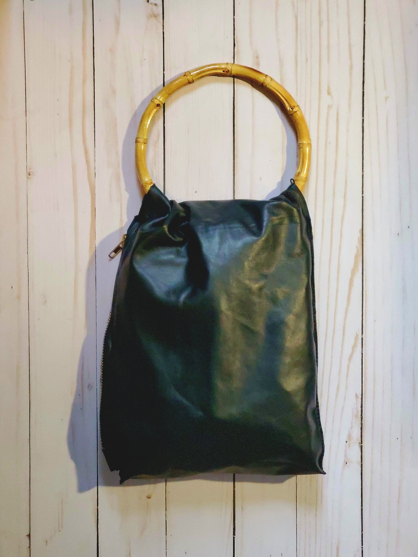 Bamboo 4 inch round handle black leather bag with a side zipper. Handmade in Los Angeles, California