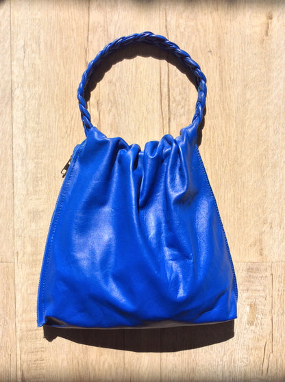 Royal blue leather bag with braided handle.